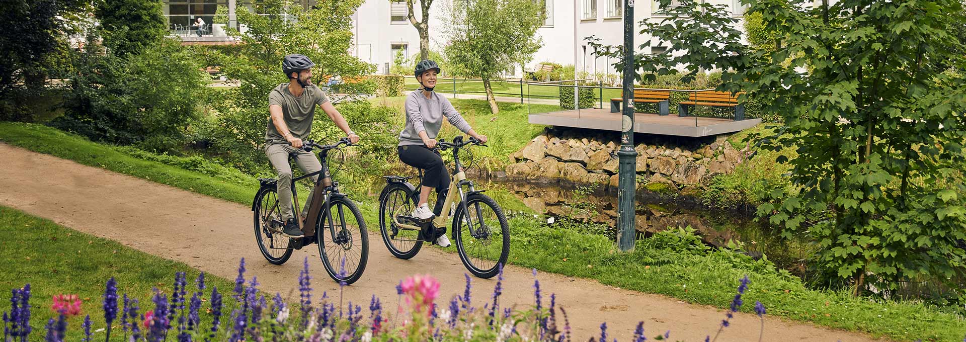 Žena i muškarac u vožnji Kreidler električnim biciklima kroz park